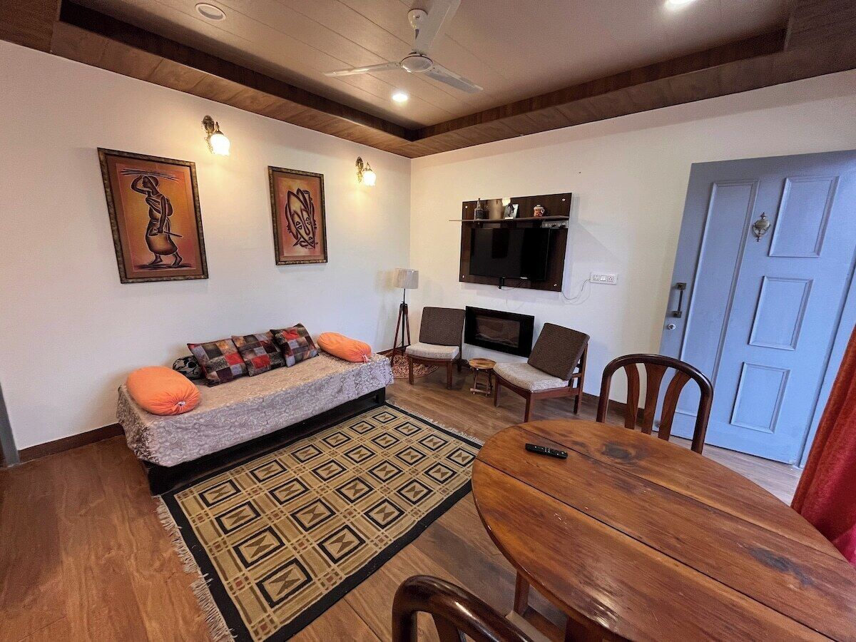 A living room with a sofa, chairs, a TV, and a dining table.