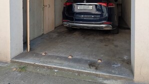 Ett fordon parkerat inuti ett garage med en stängd dörr på vänster sida.