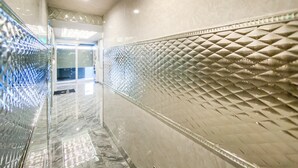 Un pasillo con paneles de vidrio reflectante y paneles de pared texturizados.