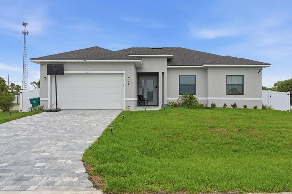 A modern two-story house with a garage, a front porch, and a well-maintained lawn. -   Spacious 3-BD Home with Private Hot Tub Near the Beautiful Boca Grande Beaches (Placida)
