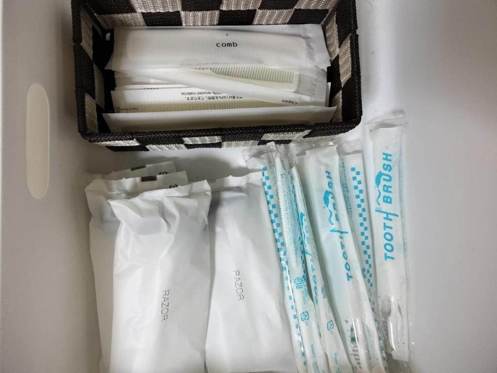 A toiletry bag with combs, razors, and toothbrushes.