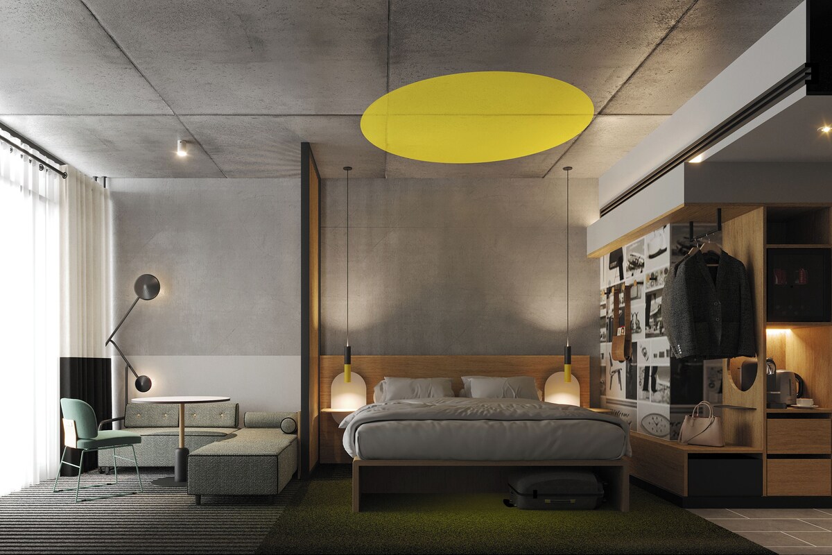 Un dormitorio moderno con cama, mesitas de noche, armario y un rincón de descanso con una silla y una pequeña mesa.