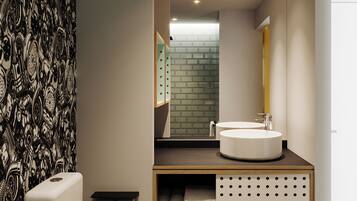 A modern bathroom with a toilet, sink, and mirror.
