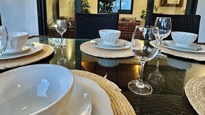 A dining area with a table set for four, including white plates, bowls, and wine glasses. - Luxury Private 3BR Villa with Private Pool Near Pereybere Beach  Sleeps 6 (Grand Baie)