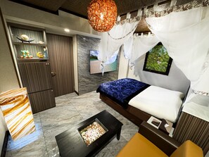 A modern bedroom with a bed, a TV, a decorative wall, and a unique ceiling light. - hotel balibali uguisudani (Tokyo)