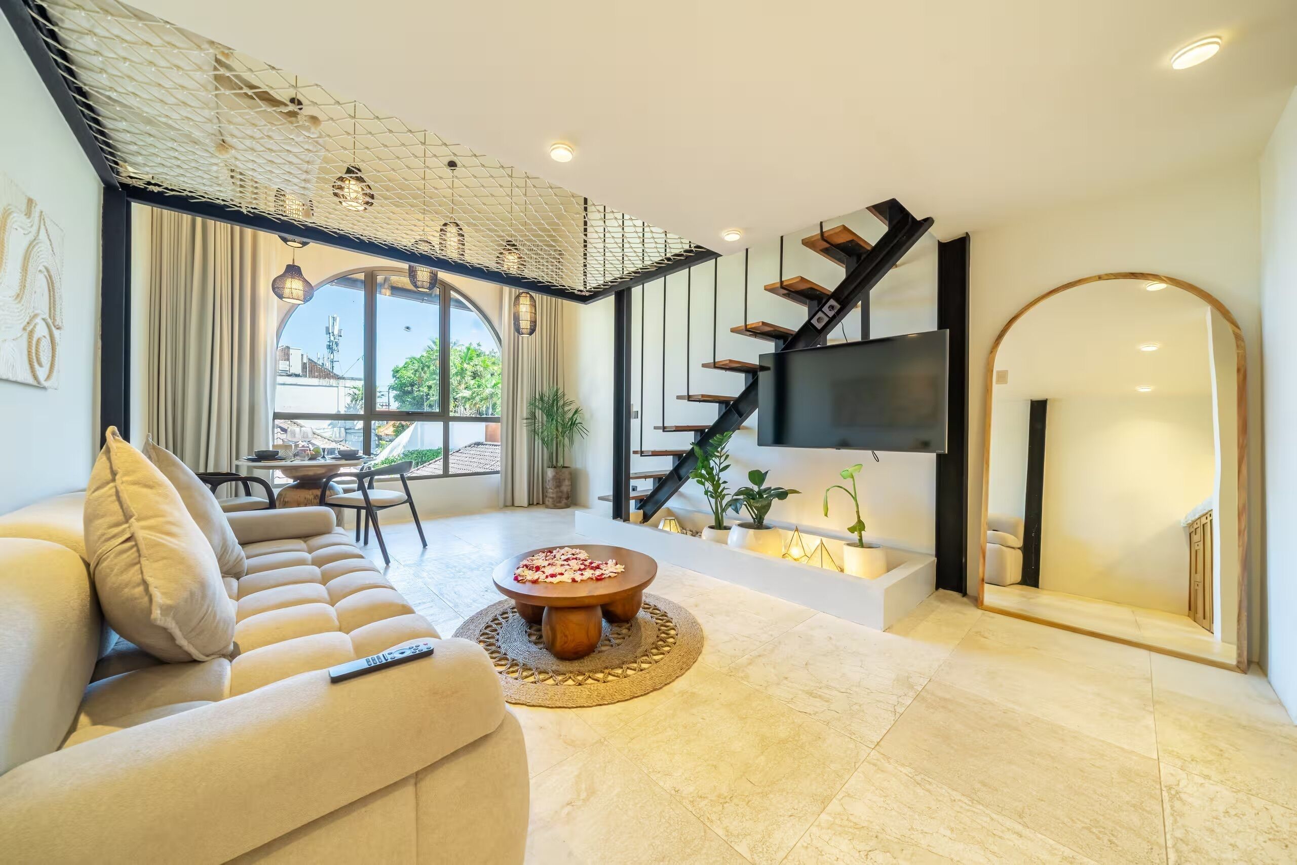 Ein modernes Wohnzimmer mit Sofa, Couchtisch und Treppe.