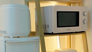 Uma cozinha com micro-ondas, torradeira e comedouro para animais de estimação.