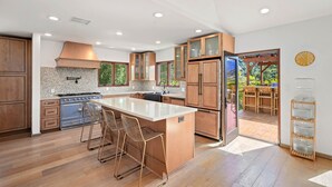 Una cocina moderna con armarios de madera, una isla grande y vistas al exterior.