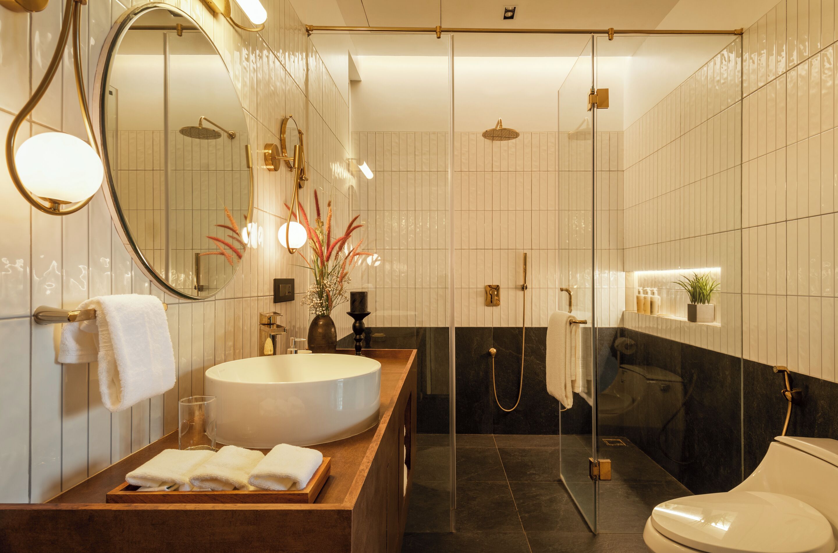 A modern bathroom with a large oval sink, a glass-enclosed shower, and a toilet.