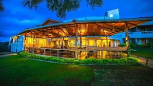 A building with a covered outdoor area, a swimming pool, and a well-maintained lawn. - Grand Palace Yercaud (Yercaud)