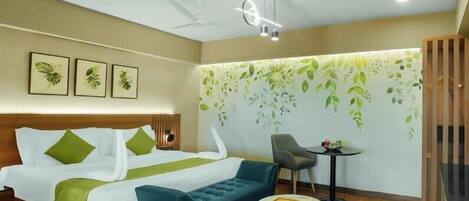 A hotel room with a bed, a sofa, a small table, and a chair.