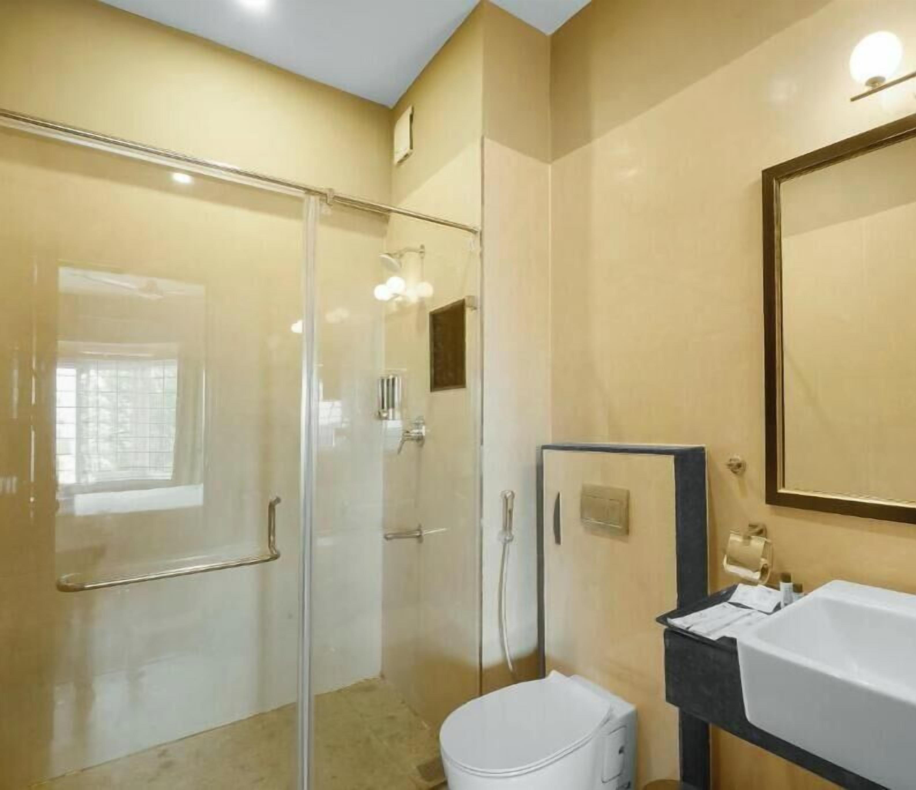 Une salle de bain avec une douche à parois de verre, un lavabo blanc et un miroir.