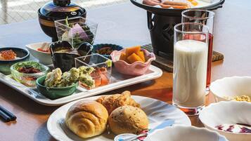 A table with various food items, including pastries, a hot pot, and beverages.