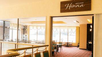 A restaurant interior with a sign reading 'Hinna,' a glass partition, and a carpeted floor.