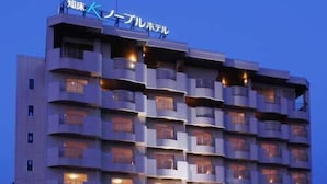 Un hotel de varios pisos con balcones y grandes ventanales.