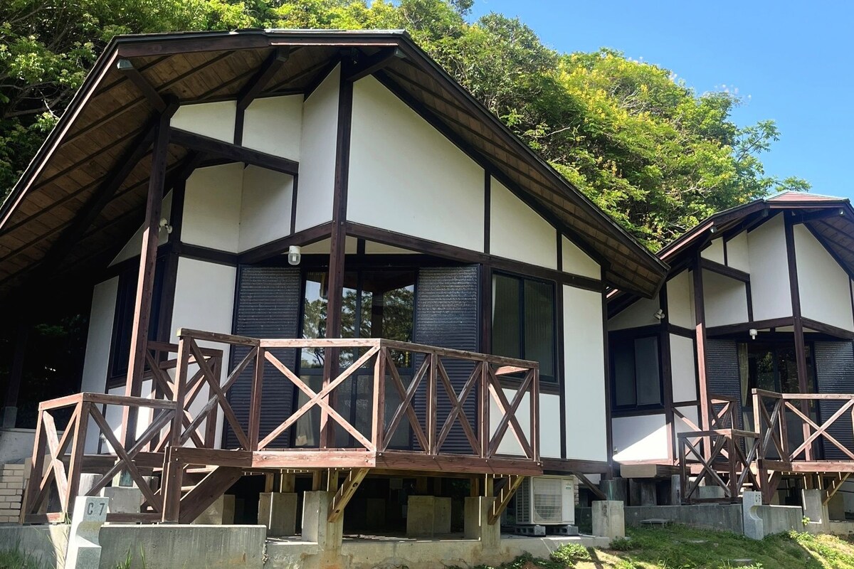 Un edificio de dos pisos con techo a dos aguas y barandillas de balcón de madera.