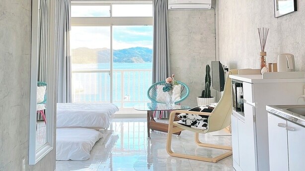 Ein Hotelzimmer mit Balkon, Essbereich und Küchenzeile.