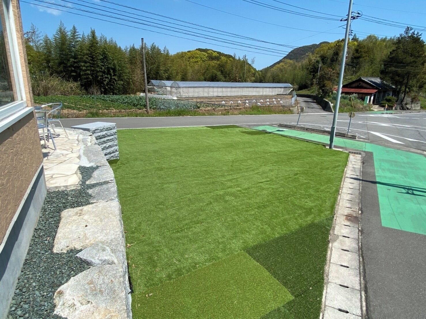 Un césped verde junto a un edificio con un borde de piedra.