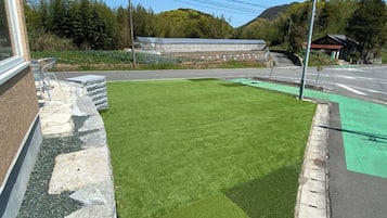 Un césped verde junto a un edificio con un borde de piedra.