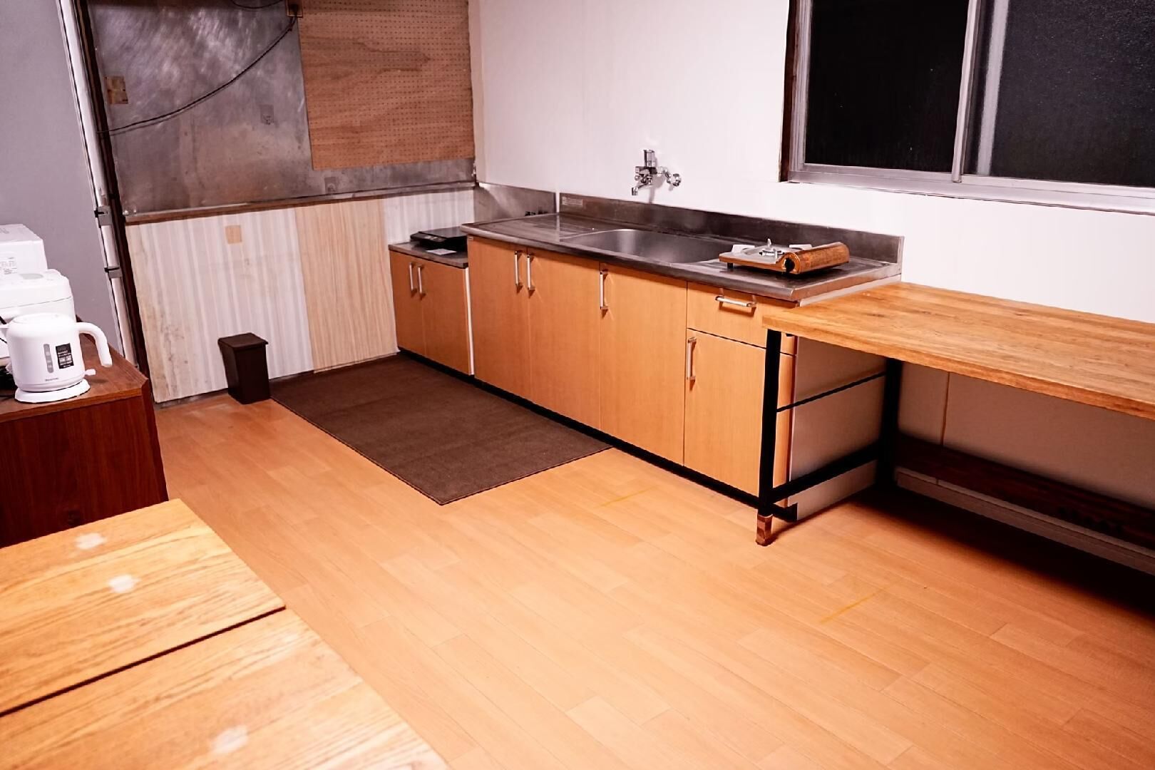 A compact kitchen with wooden cabinets, a stainless steel sink, and a window.