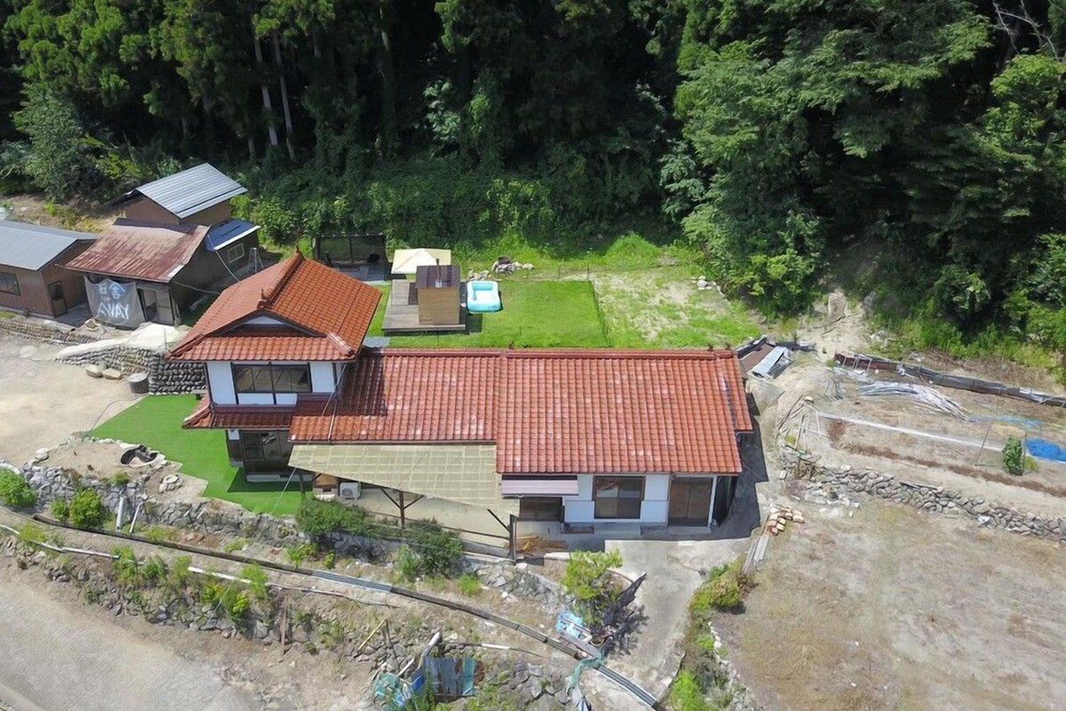 Um bairro residencial com várias casas, um caminho de acesso pavimentado e um pequeno gramado verde.