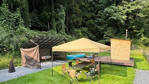 Una zona de pati amb taula i cadires, una barbacoa i una petita piscina.