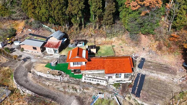 Vista aèria d'una zona residencial amb cases, una via fèrria i una zona verda.