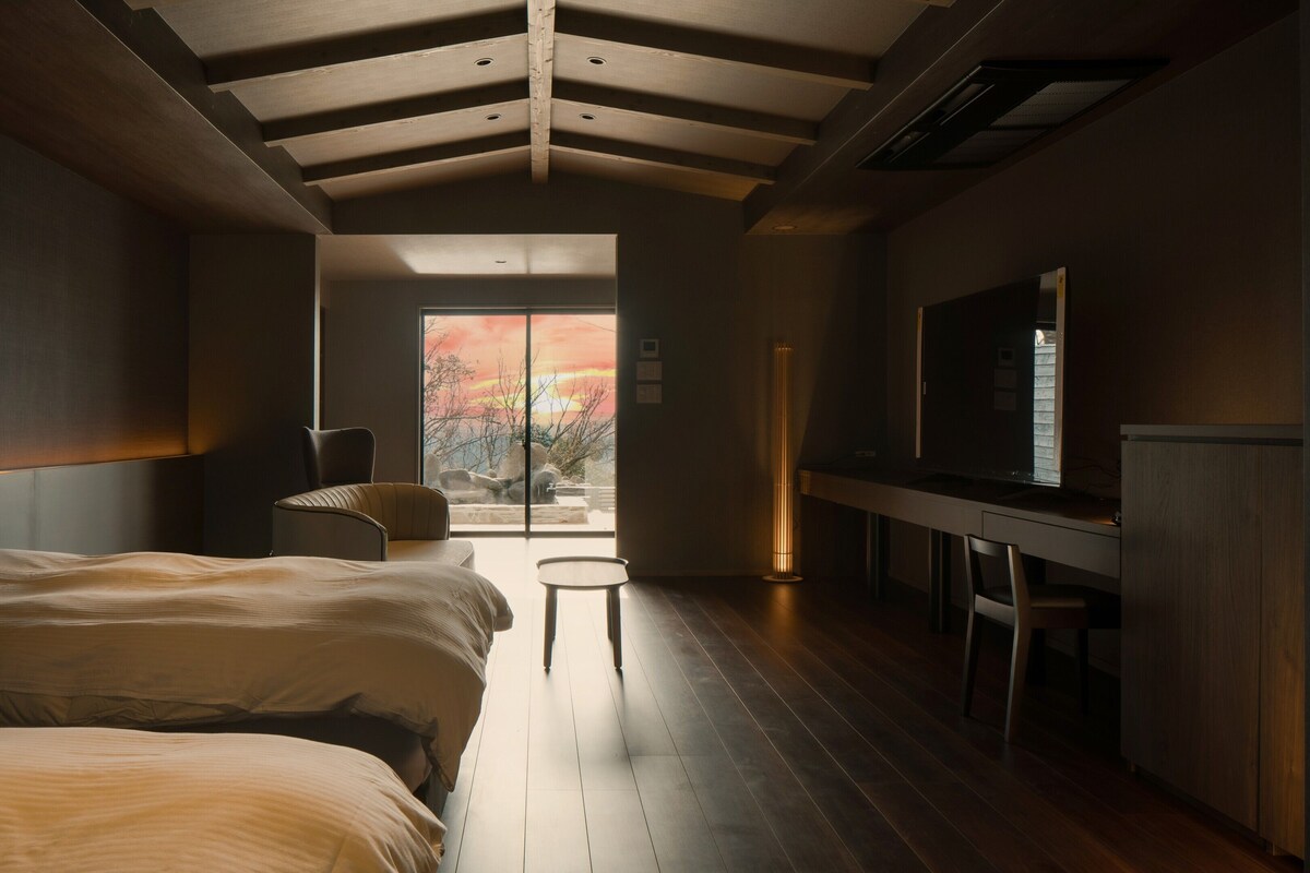 Een moderne hotelkamer met een groot bed, een bureau, een televisie en uitzicht op de omgeving.