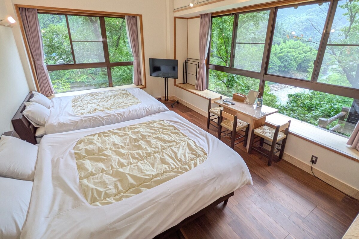 Una habitación con dos camas, un escritorio y un televisor.