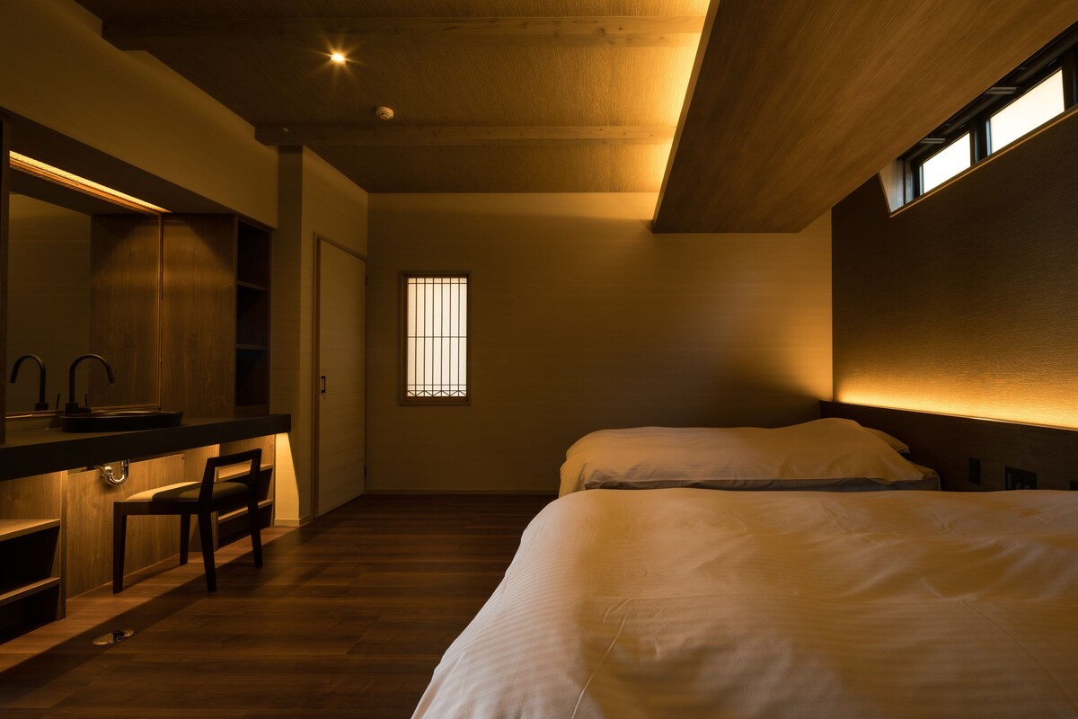 Un dormitorio con una cama, un escritorio con espejo y una ventana con barrotes.