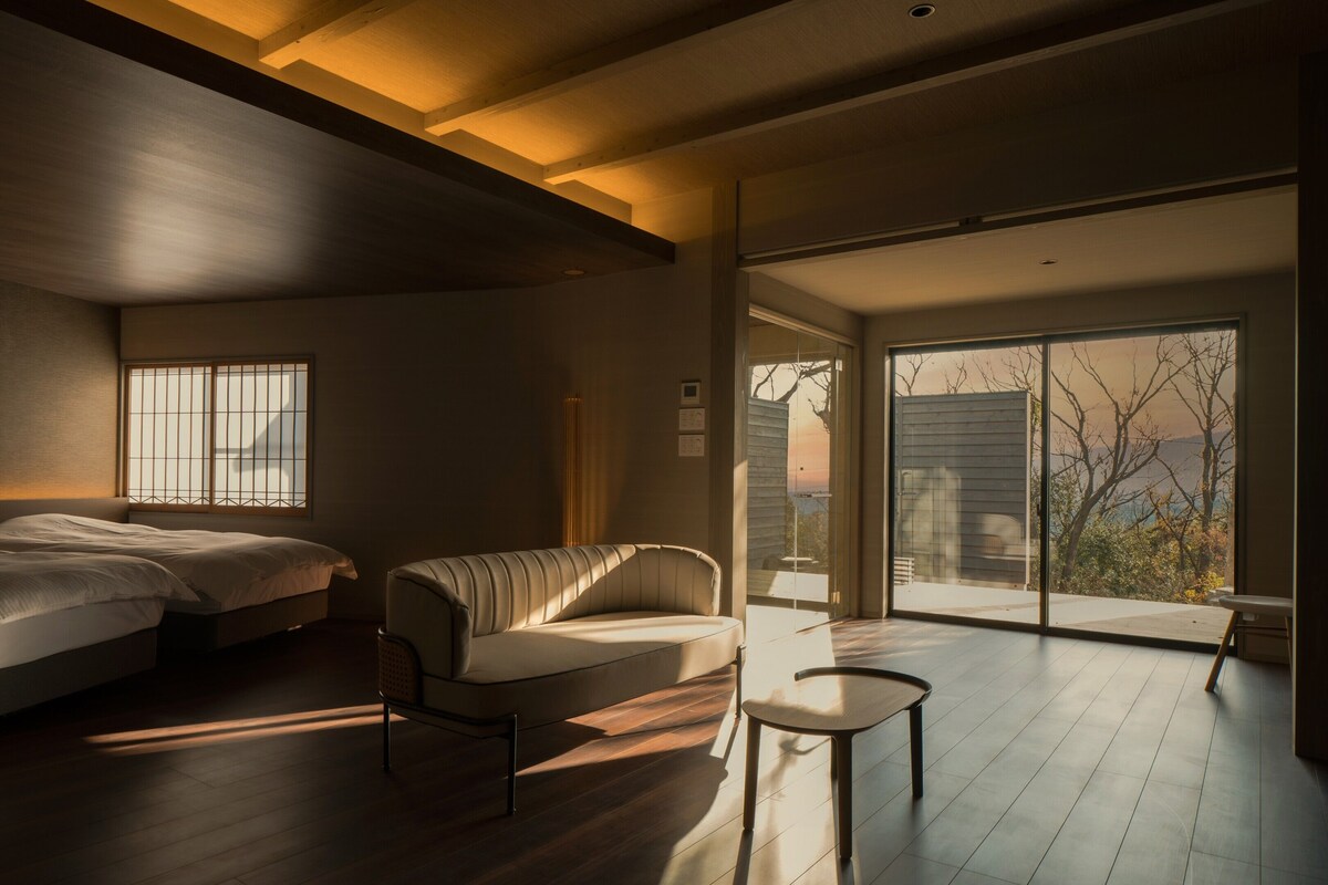 Een moderne slaapkamer met twee bedden, een bank en een kleine tafel.