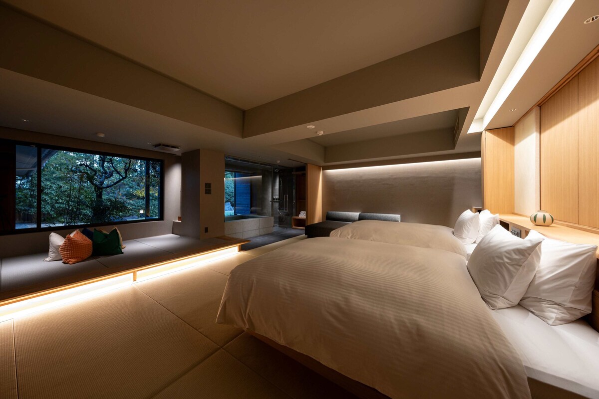 Quarto moderno com uma cama grande, área de estar com vista e um banco embutido.