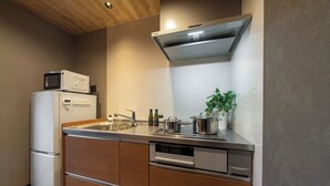 A compact kitchen with a microwave, sink, and stainless steel appliances. - Activity Base Hida-takayama (Takayama)
