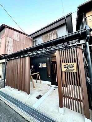 A building entrance with a wooden gate, a signboard, and a small awning. - Activity Base Hida-takayama (Takayama)