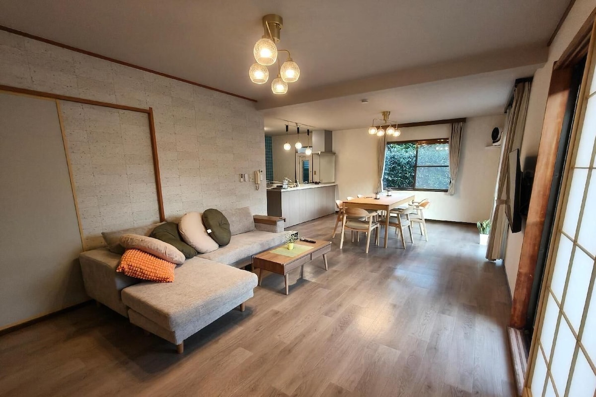 A modern living room with a sofa, coffee table, and dining area.