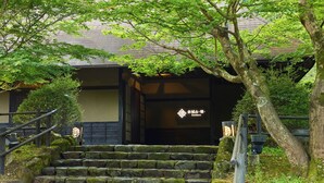 A traditional Japanese building with a stone staircase leading to a wooden entrance.