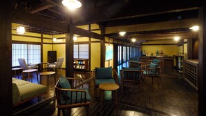 A traditional Japanese-style room with tatami flooring, wooden furniture, and a bar area.