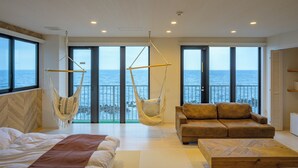 Une pièce spacieuse avec un grand lit, un canapé et deux hamacs.