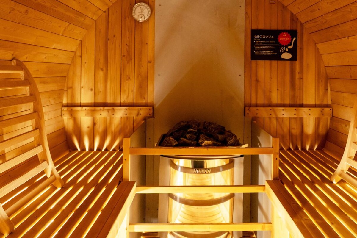 A sauna with wooden benches and a central heating element.