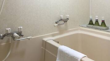 A bathroom with a bathtub, a towel rack, and a shelf with bottles.