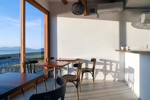 A balcony with a table and chairs, overlooking a scenic view.