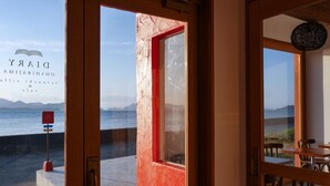 Entrada de un hotel costero con vistas al mar y a las montañas.