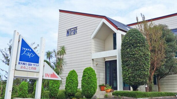 A building with a sign indicating it is a hotel. - Petit Hotel North Inn (Ito)