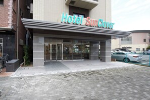A hotel entrance with a modern design, featuring a prominent sign that reads 'Hotel Sunflower.'