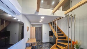 A modern interior with a staircase, a dining area, and a kitchen. - B2 - SASHA Loft by SDR (Paralia)