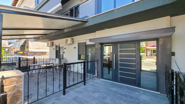 A modern building with a covered outdoor area, a gated entrance, and air conditioning units. - B2 - SASHA Loft by SDR (Paralia)