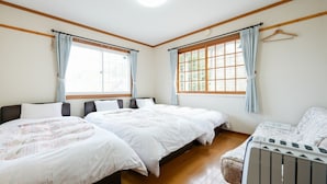 A room with two beds, a radiator, and large windows with curtains. - Pension Mascot (Tsumagoi)