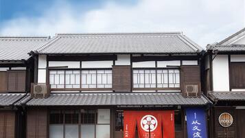 A traditional Japanese building with a tiled roof, wooden structure, and large windows.
