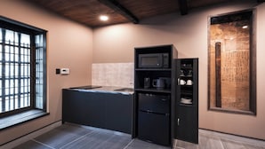 A modern kitchen with a microwave, coffee maker, and a refrigerator.