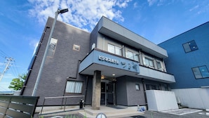 A modern building with a flat roof, large windows, and a sign indicating it is a hotel. - Business Hotel Tsuruya (Sakai)
